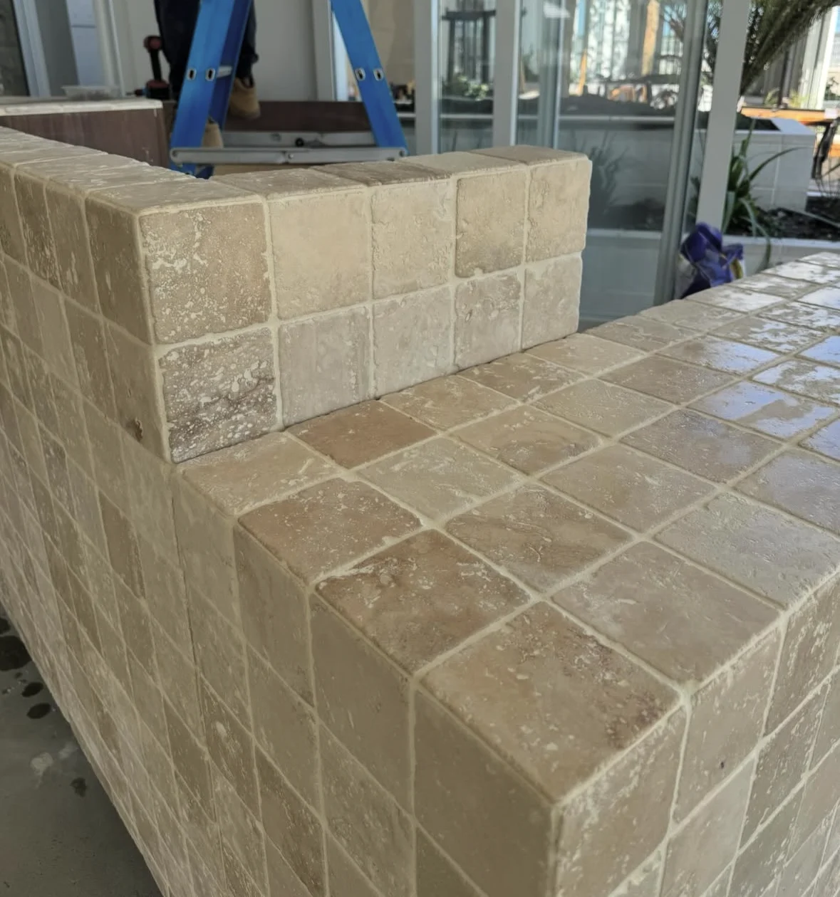 Travertine tiles wrapping a restaurant counter during installation
